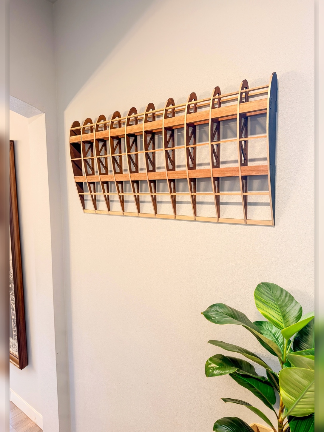 Flightline Furniture Elevator
                  wing rib wall art — right profile mounted on wall — red oak — potted tree in background —
                  Corvallis Oregon
