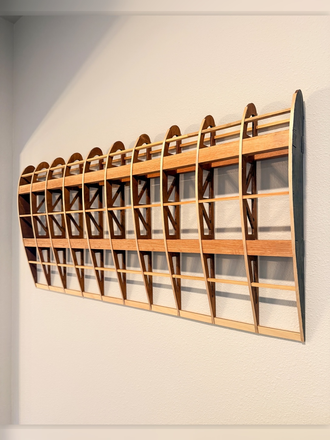 Flightline Furniture Elevator
                  wing rib wall art — right profile mounted on wall showing wing rib geometry detail — red oak —
                  Corvallis Oregon